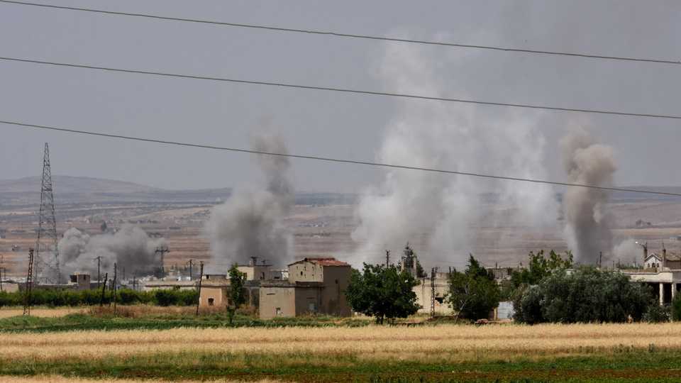 A picture taken from the village of Kfar Hud shows smoke billowing above buildings as pro-regime forces pound the village of Tal Meleh with tank and aerial fire in Syria’s Hama governorate on June 9, 2019.