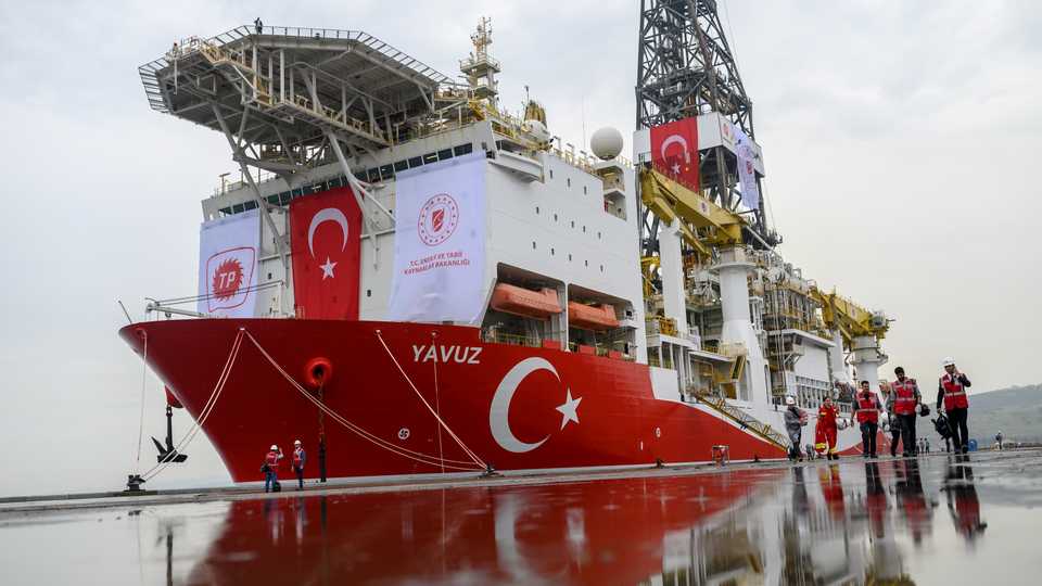 Journalists walk next to the drilling ship 'Yavuz' scheduled to search for oil and gas off Turkish Republic of Northern Cyprus at the port of Dilovasi outside Istanbul, on June 20, 2019.