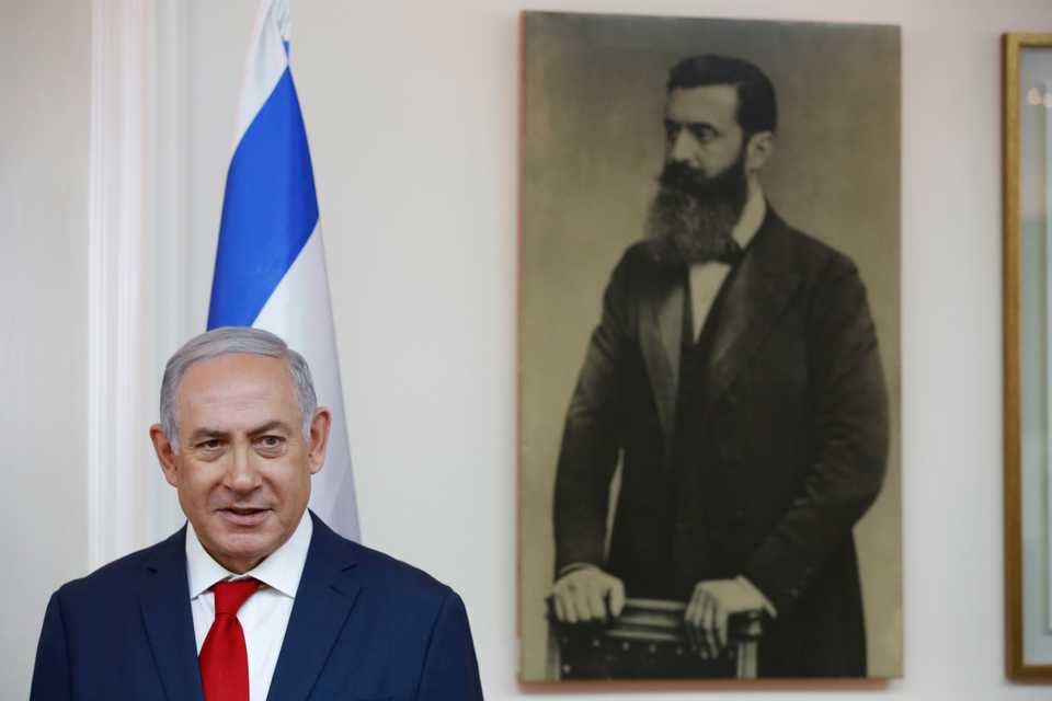 Israeli Prime Minister Benjamin Netanyahu next to a picture of the founder of Zionism, Theodor Herzl, ahead of his meeting with Japanese Prime Minister Shinzo Abe, at the Prime Minister's Office in Jerusalem on May 2, 2018.