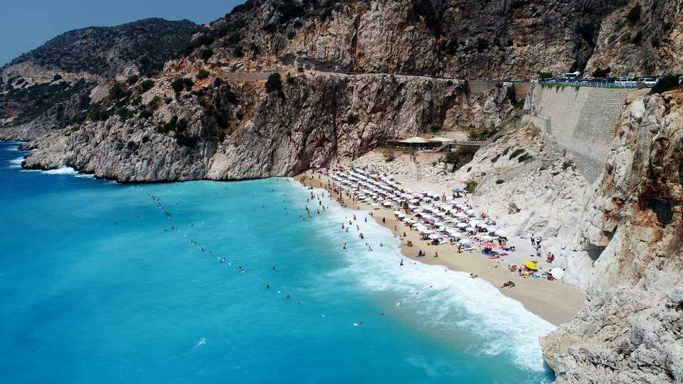People enjoy the Kaputas Beach during a summer day in the resort town of Kalkan in Turkey's Antalya province on August 27, 2018.
