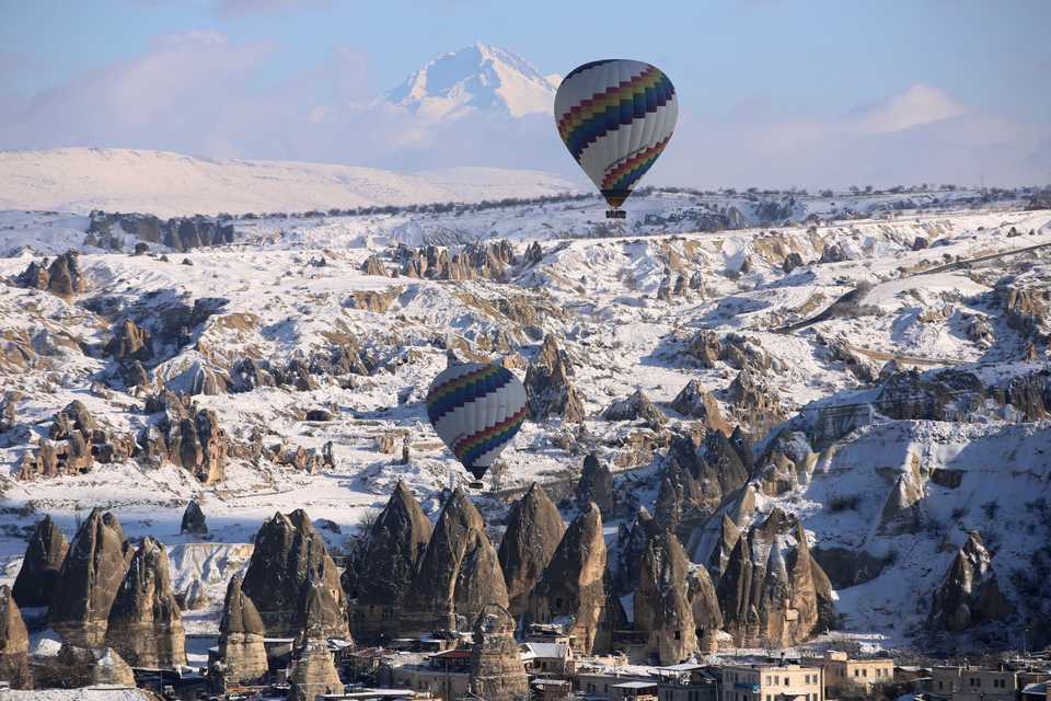 Hot-air balloons glide above fairy chimneys in the historical Cappadocia region, a UNESCO world heritage site, in Central Anatolia's Nevsehir province, Turkey on December 28, 2018.