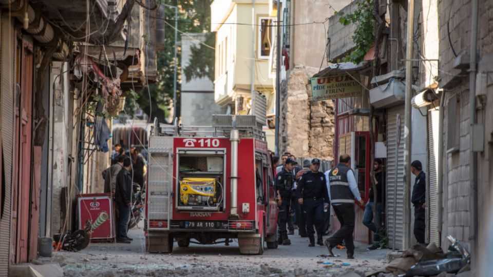 Turkish police officers inspect the area after rocket projectiles hit the roof of a house in Kilis, Turkey on April 18, 2016. 