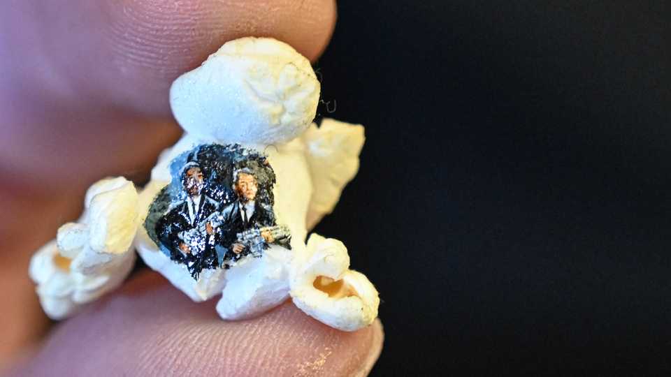 This picture shows two armed men in black painted on a popcorn by Turkey's micro artist Hasan Kale in Istanbul. August 23, 2019.