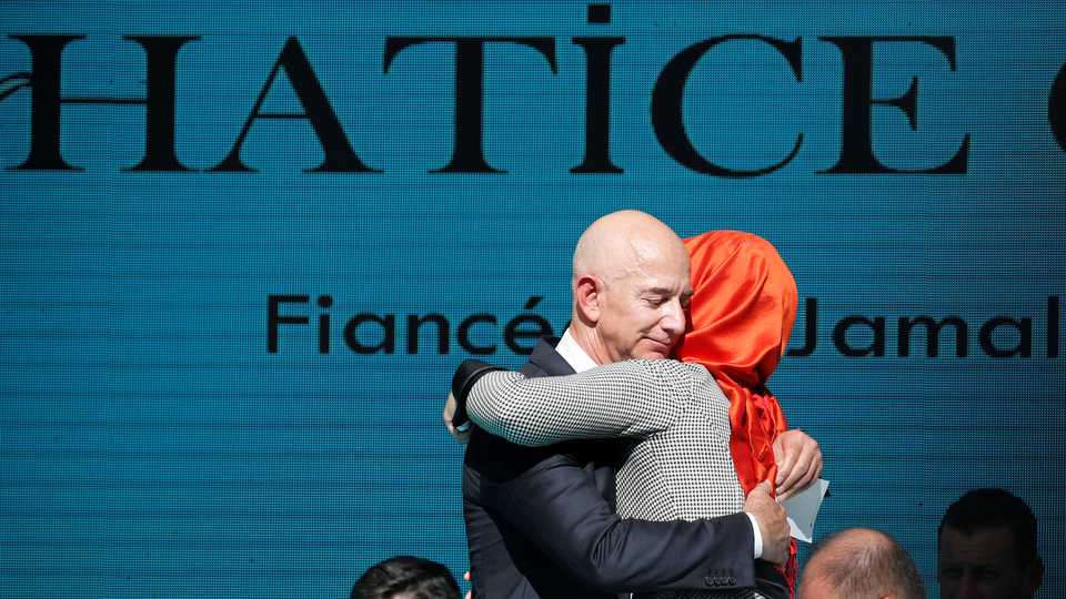 Hatice Cengiz (L), fiancee of the murdered Saudi journalist Jamal Khashoggi, and Jeff Bezos, founder of Amazon, embrace each other as they attend a ceremony marking the first anniversary of Khashoggi's killing at the Saudi Consulate in Istanbul.