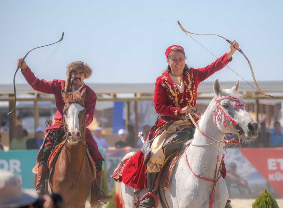 A man and a woman are pictured at the horseback archery event at the Ethnosport Culture Festival being hosted at Istanbul's Ataturk Airport. October 3, 2019.