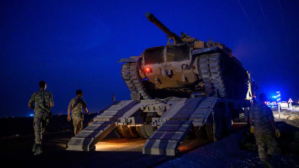 A Turkish army's tank drives down from a truck as Turkish armed forces drive towards the border with Syria near Akcakale in Sanliurfa province on October 8, 2019.