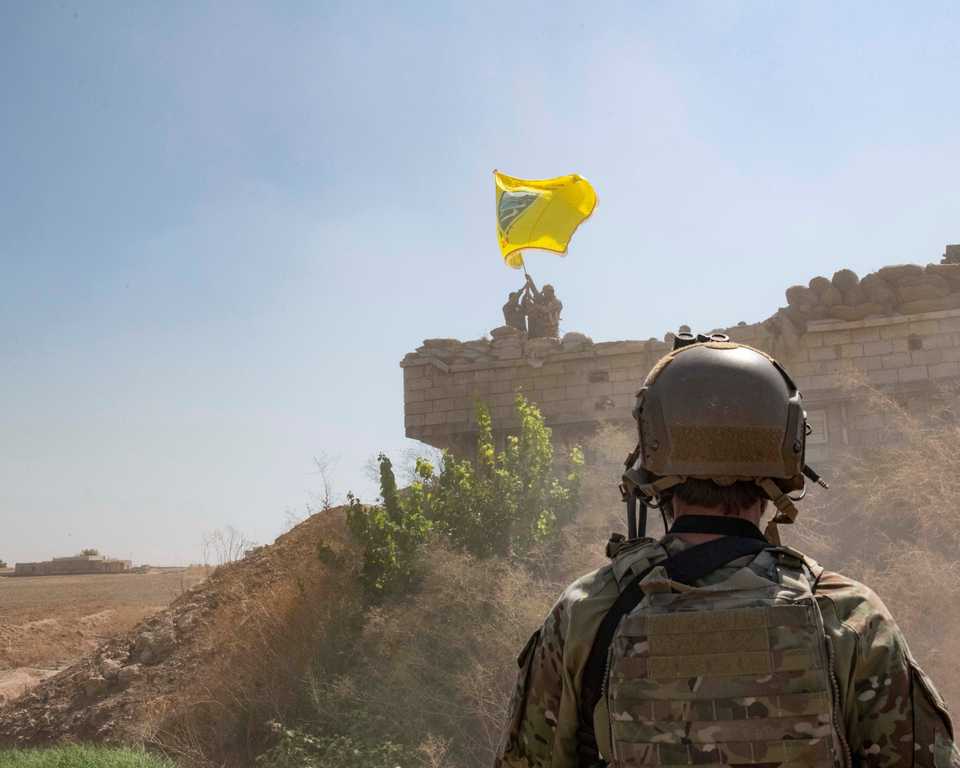 A US soldier oversees members of SDF as they demolish a YPG fortification and raise a Tal Abyad Military Council flag over the outpost as part of the security mechanism zone agreement between the US and Turkey in Syria September 21, 2019.