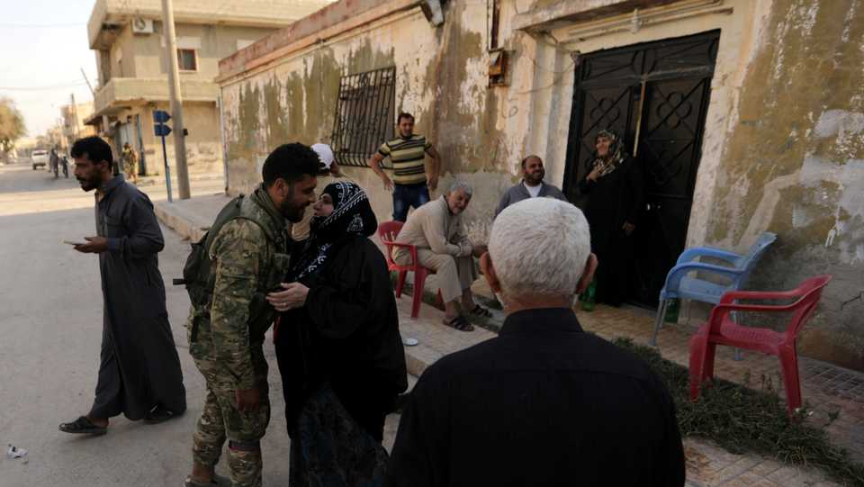 A Turkey-backed Syrian opposition fighter is greeted by a woman in the town of Tal Abyad, Syria October 13, 2019.
