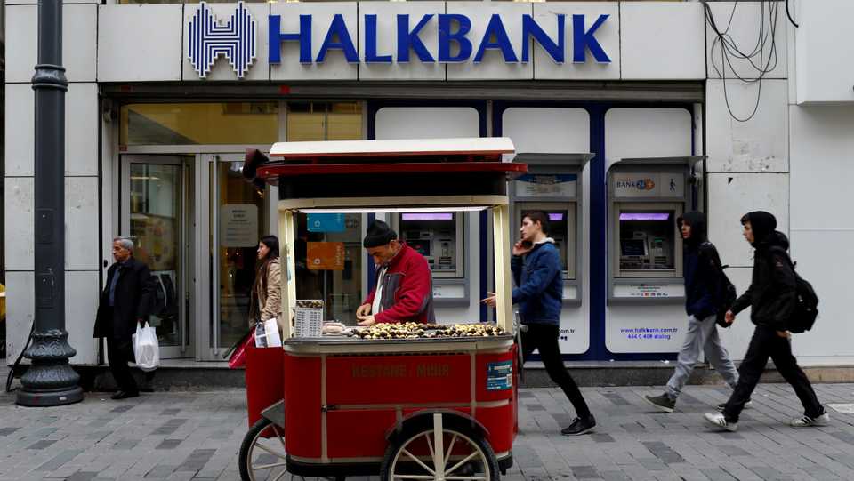A street vendor sells roasted chestnuts in front of a branch of Halkbank in central Istanbul, Turkey. January 10, 2018.