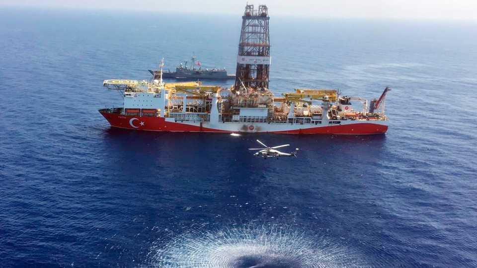 In this Tuesday, July 9, 2019 photo, a helicopter flies near Turkey's drilling ship, 'Fatih' dispatched towards the eastern Mediterranean, near the Turkish Republic of Northern Cyprus.