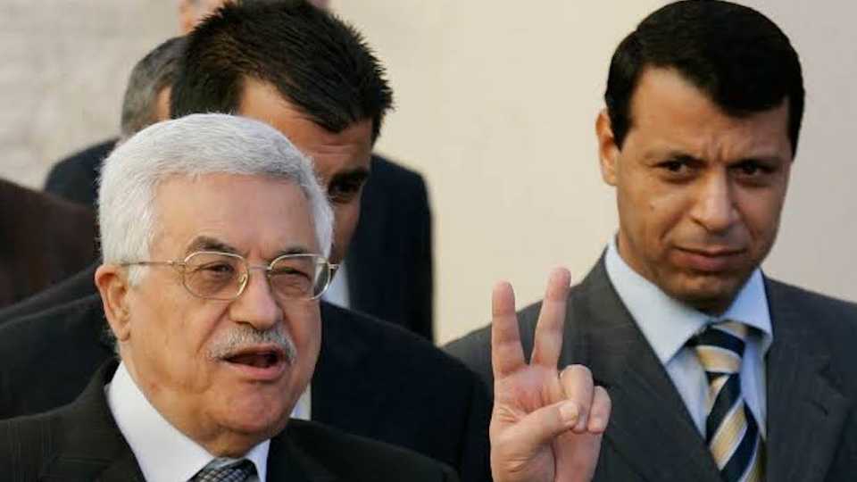 Palestinian Authority President Mahmoud Abbas, also known as Abu Mazen, left, flashes the V-sign as then Fatah leader, Mohammed Dahlan (R), looks on after their meeting with British Prime Minister Tony Blair, not seen, outside Abbas' office in the West Bank town of Ramallah.