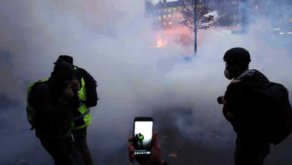 Security forces attempt to disperse protests with tear gas canisters during a general strike over French government's plan to overhaul the country's retirement system, in Paris, France on December 05, 2019.