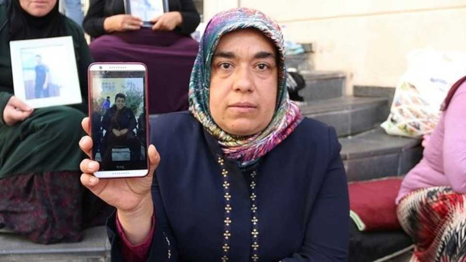 Hatice Ceylan poses with the picture of her son, Cafer Ceylan, in front of the HDP HQ in Turkey's Diyarbakir in this file photo.