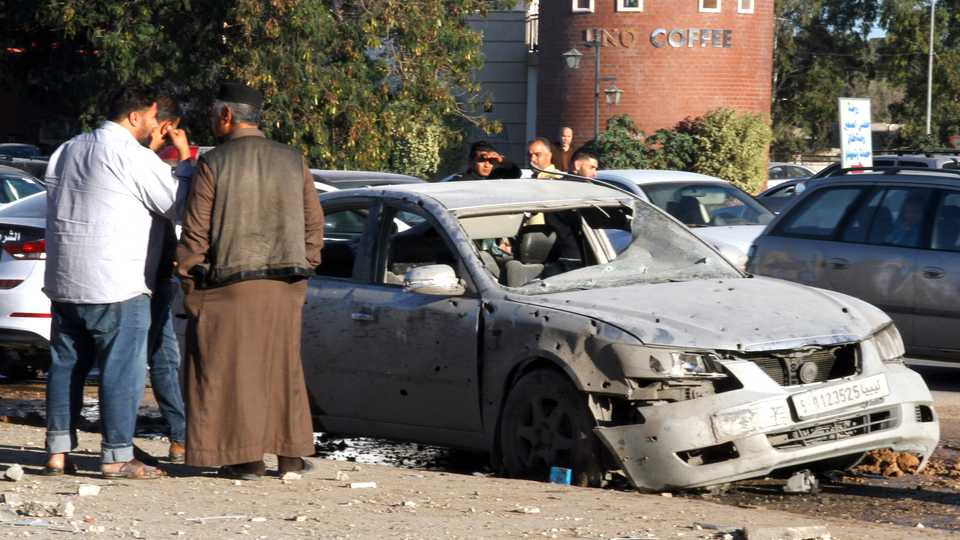 Libyans check the site of an air strike in the town of Zawiya, 45 kilometres west of Tripoli which killed at least two civilians and wounded 20 others, a local official said, December 26, 2019