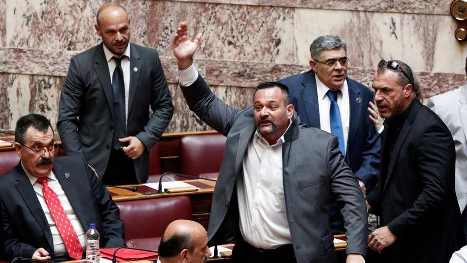 Lawmaker of far-right Golden Dawn party Ioannis Lagos (C) yells as he enters a parliament session in Athens, June 4, 2014.