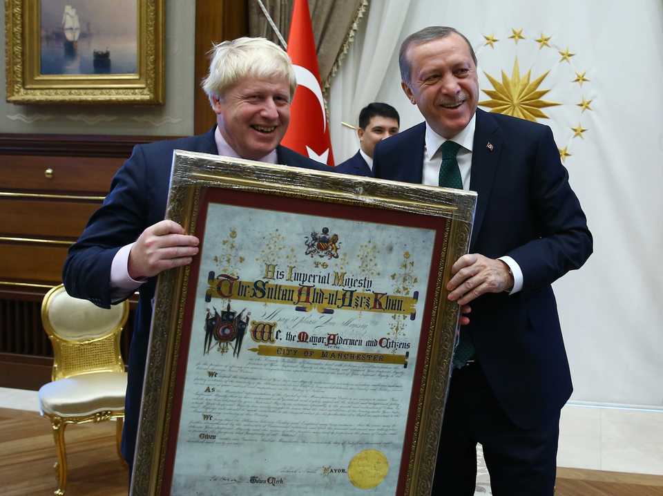 Turkey's President Recep Tayyip Erdogan, right, gives a replica of a historical document signed by Ottoman Sultan Abdulaziz Khan as a gift to British Foreign Secretary Boris Johnson, after a meeting in Ankara, Turkey on Sept. 27, 2016.