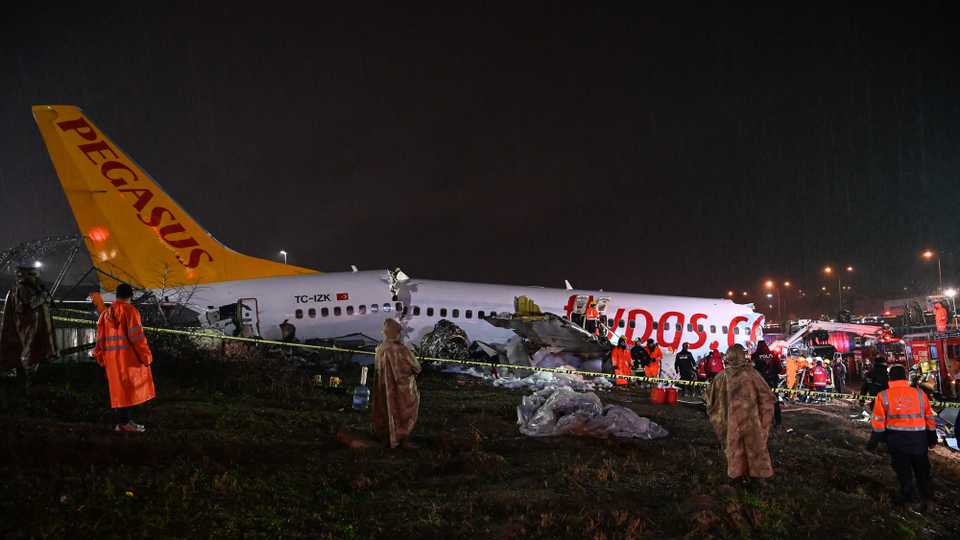 Turkish soldiers stand guard as rescuers work at the crash of a Pegasus Airlines Boeing 737 airplane, after it skidded off the runway upon landing at Sabiha Gokcen airport in Istanbul on February 5, 2020.