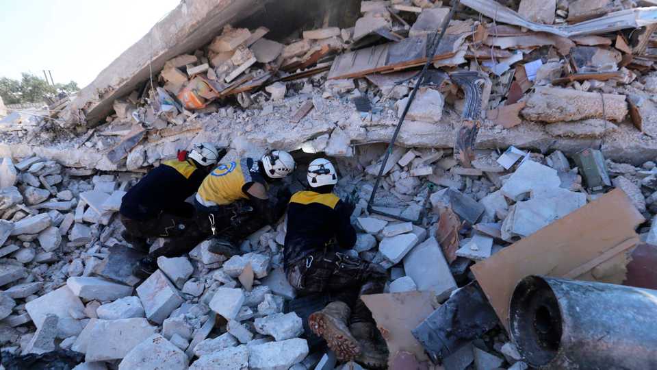 Syrian rescuers search for victims between rubble of a destroyed house after air strikes at the northern town of Sarmin, in Idlib province, Syria, Sunday, February 2, 2020.