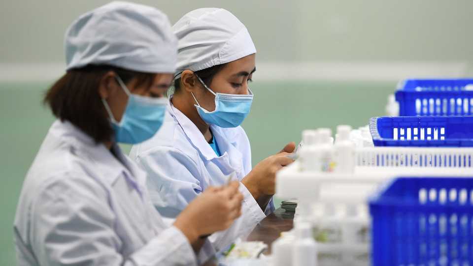 Workers manufacture hand sanitizer at a factory in Hanoi on February 14, 2020 amid concerns of the COVID-19 coronavirus outbreak.