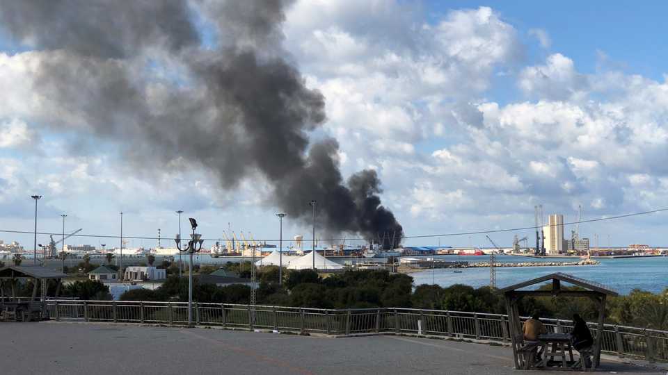 This file photo shows smoke rising from a port of Tripoli in Libya after being attacked. February 18, 2020.