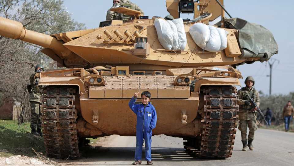 A Syrian boy stands in front of a Turkish military vehicle east of Idlib city in northwestern Syria on February 20, 2020, amid ongoing regime offensive on the last major rebel bastion in the country's northwest.