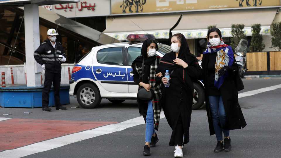 A policeman and pedestrians wear masks to help guard against the Coronavirus, in downtown Tehran, Iran, Sunday, February 23, 2020.