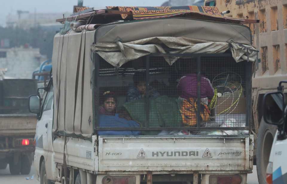 Displaced Syrian children sit at the back of a truck with belongings, in the town of Sarmada in Idlib province, Syria, January 28, 2020.