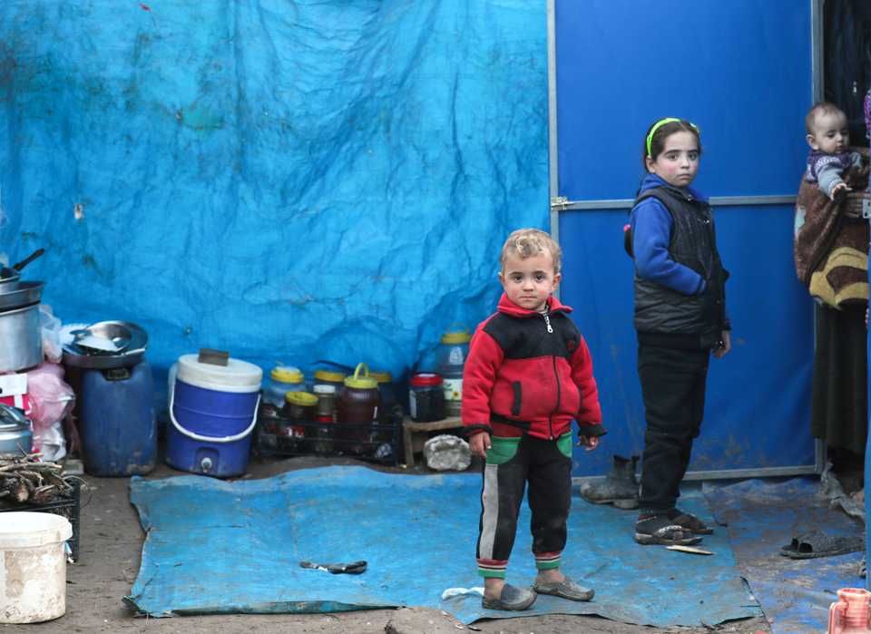Displaced Syrian children, who fled from southern Idlib, stand outside a tent in Afrin, Syria February 6, 2020. Picture taken February 6, 2020.