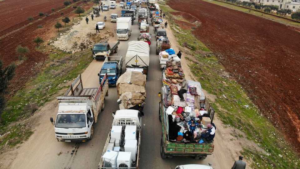 An aerial photo shows displaced Syrians driving through Hazano in the northern countryside of Idlib, after fleeing on January 28, 2020 its southern countryside towards areas further north near the border with Turkey.