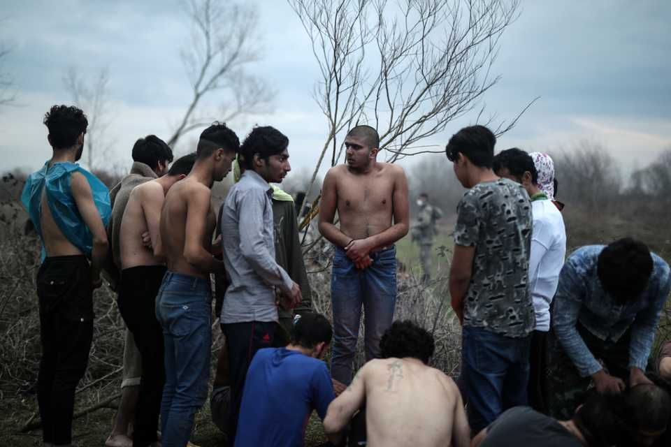 Young migrants gather around a small fire to keep warm. (Belal Khaled / TRT Arabi)