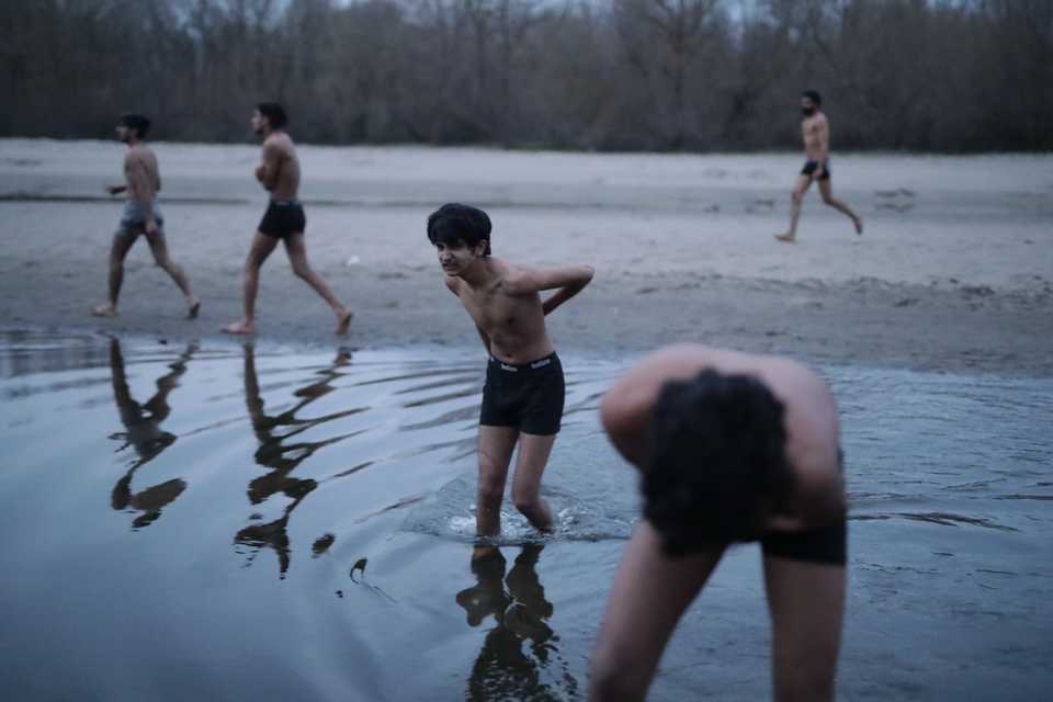 Refugees wash their wounds before rushing towards wood fires to heat themselves up after Greek border police stripped them of their clothes and beat them up before pushing them towards the Turkish side of no man's land at the Edirne-Kastanies border in Uzunkopru in Edirne. March 5, 2020. (Belal Khaled / TRT Arabi)
