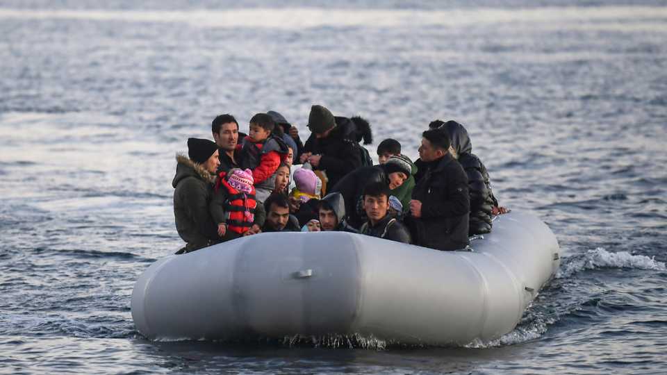Refugees and migrants aboard an inflatable boat arrive on the Greek island of Lesvos on March 2, 2020.