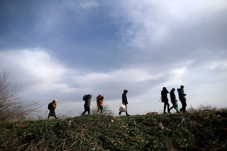 Migrants walk in Edirne at the Turkish-Greek border, Monday, March 9, 2020.