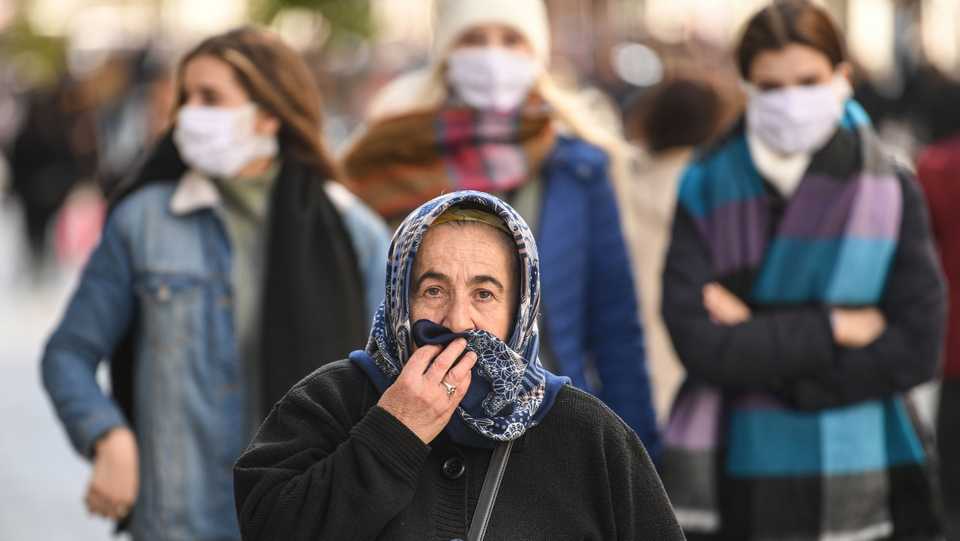 People wear protective face masks as they walk along Istiklal Avenue as the nation tries to contain the novel coronavirus. March 17, 2020.