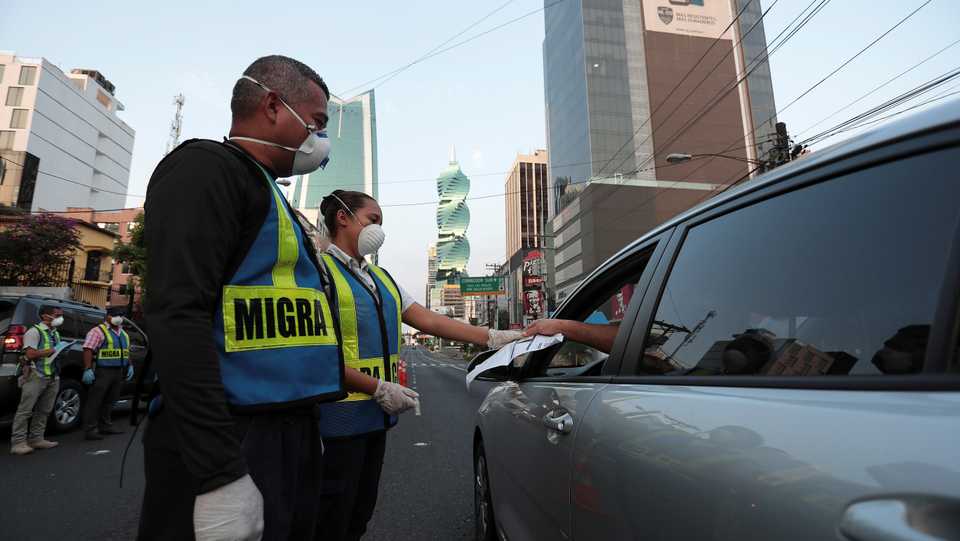Police officers check the documents of a driver during the curfew as the coronavirus disease (COVID-19) outbreak continues, in Panama City, Panama March 31, 2020.