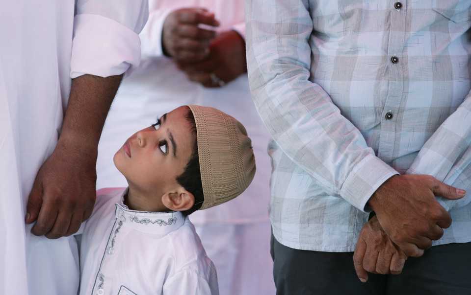 A Muslim boy looks on as others offer Eid al-Fitr prayers to mark the end of the holy fasting month of Ramadan in Chennai, India June 5, 2019.