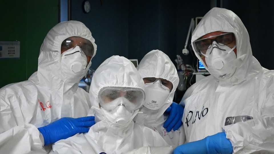 Health workers, wearing protective gear pose at the end of their shift at the level intensive care unit, treating Covid-19 patients, at the San Filippo Neri hospital in Rome, on April 20, 2020.