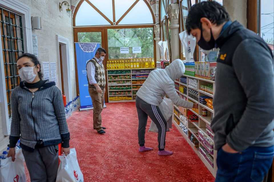 In this April 21, 2020 file photo, those in need can be seen taking food supplies at the entrance of the Dedeman mosque, where shoe racks are now loaded with food for those who lost their livelihoods amid the Covid-19 pandemic.