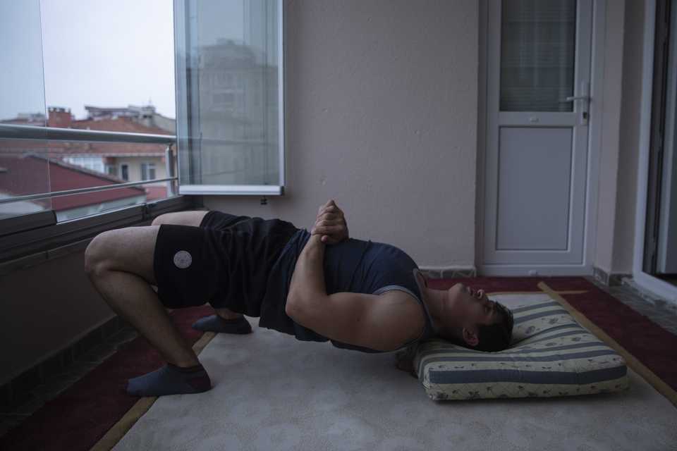 Wrestler Sezen Bora trains at the balcony of his house in Edirne, Turkey.