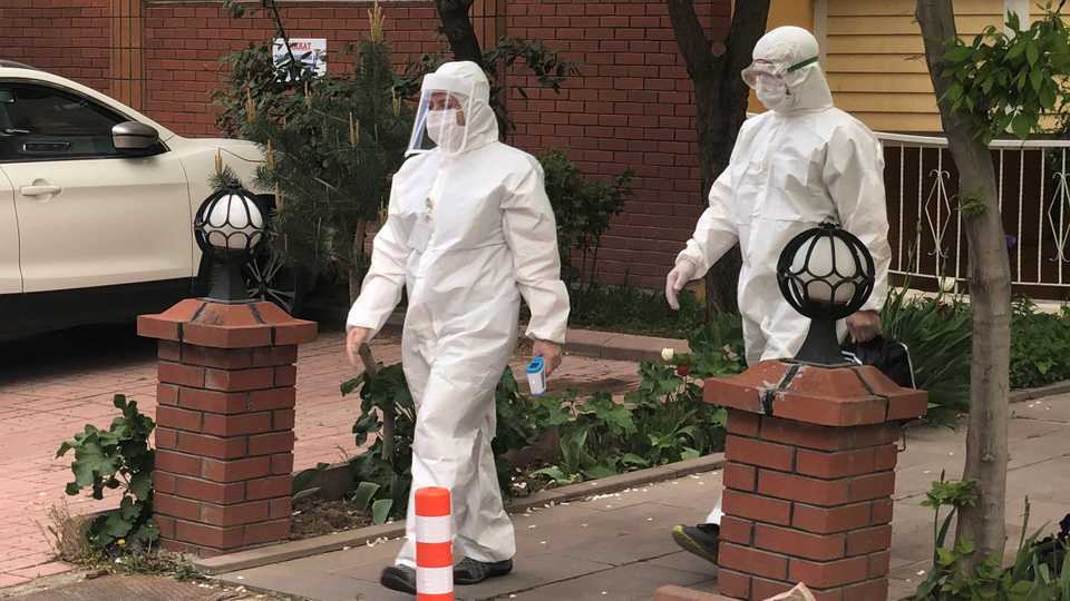 Medics wearing protective suits, members of Turkish Health Ministry's coronavirus contact-tracing team, leave after visiting a home to check a suspected coronavirus disease (Covid-19) case in Ankara, Turkey, April 27, 2020.