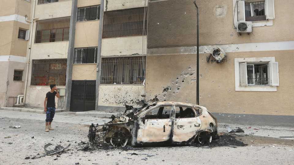A car wreckage is seen near buildings after a rocket attack by warlord Khalifa Haftar's militia on Bab Bin Ghashir area of Tripoli, Libya on May 9, 2020.