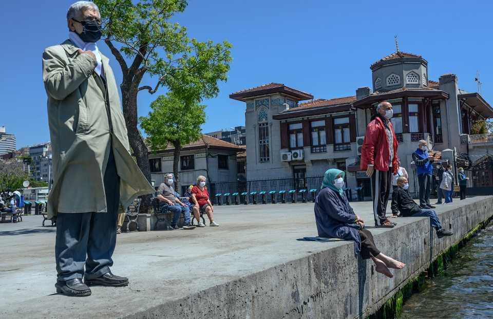 Elderly people wearing protective face masks look at the Bosphorus on May 10, 2020, at Besiktas, Istanbul.