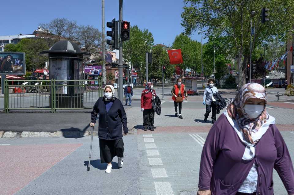 Elderly people wearing protective face masks walk towards the seaside on May 10, 2020, at Besiktas, Istanbul.