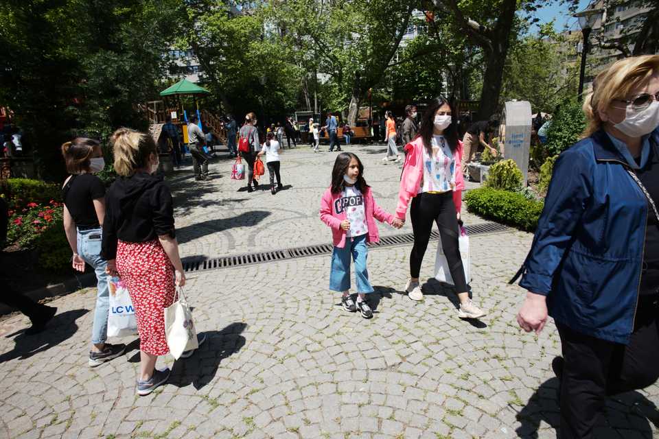 Children wearing face masks for protection against the coronavirus, walk in Kugulu public garden, in Ankara, Turkey, Wednesday, May 13, 2020.