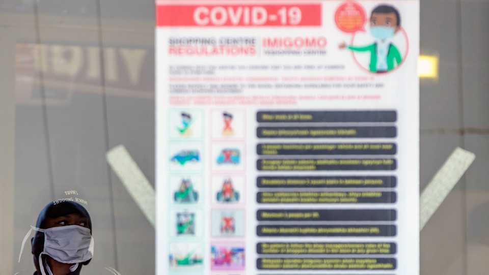 A woman wearing face masks to protect against coronavirus, walks past a closed pharmacy following undisclosed positive Covid-19 case in Alberton, east of Johannesburg, South Africa. May 15, 2020.