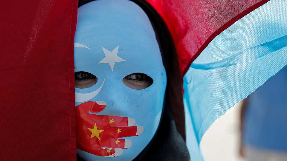 An ethnic Uighur demonstrator wears a mask as she attends a protest against China in front of the Chinese Consulate in Istanbul, Turkey, October 1, 2019.