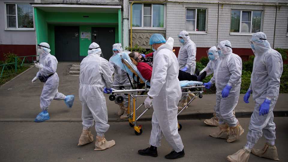 Paramedics and members of the Emergencies Ministry wearing personal protective equipment (PPE) use a stretcher while transporting a patient amid the coronavirus disease (COVID-19) outbreak in the city of Tver, Russia May 28, 2020.