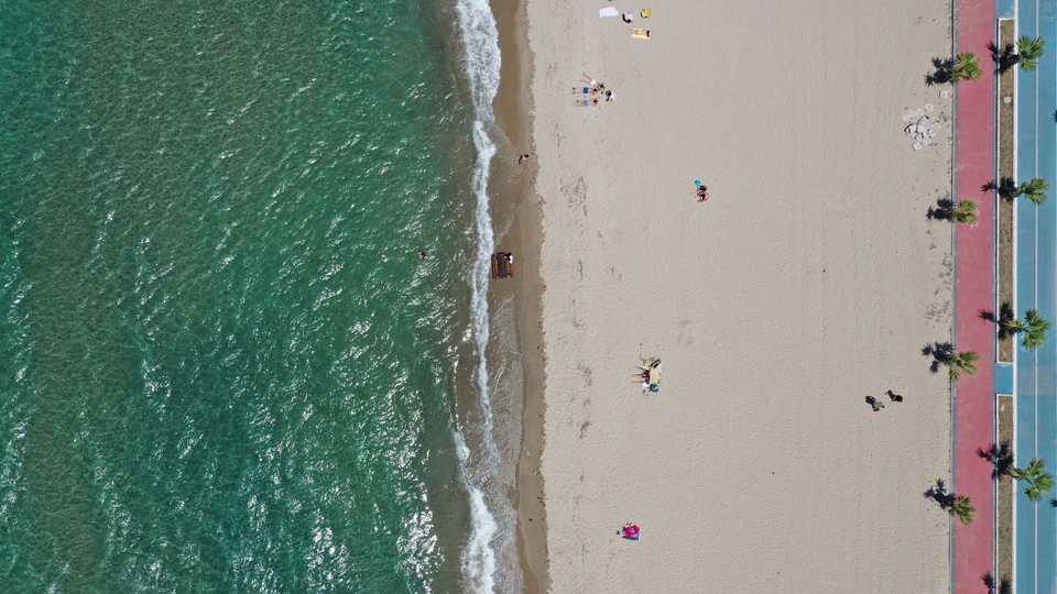 A drone photo shows people at the beach in Kusadasi complying with social distancing rules as a precaution against coronavirus (Covid-19) pandemic in Aydin, Turkey on June 07, 2020.