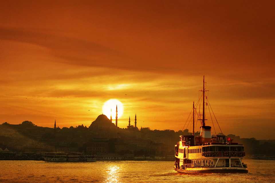 Sunset over Istanbul as a passenger ferry makes its way from the Anatolian side to the European side.