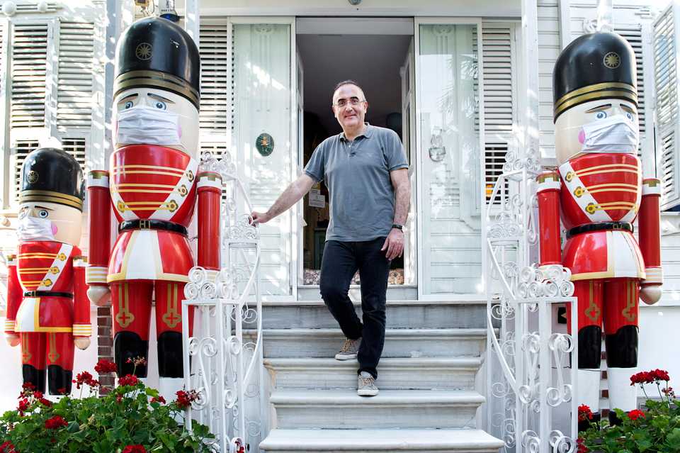Istanbul Toy Museum founder Sunay Akin poses in front of his popular museum, surrounded by oversize toy soldiers wearing face masks.